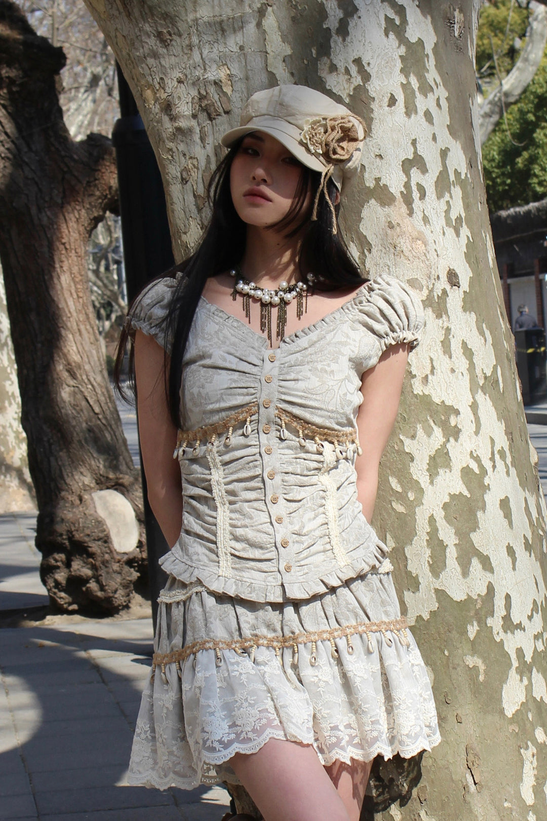 4RE1GN SHELL jacquard blouse and lace skirt separates in ivory — outdoor front modeled view leaning beside a tree