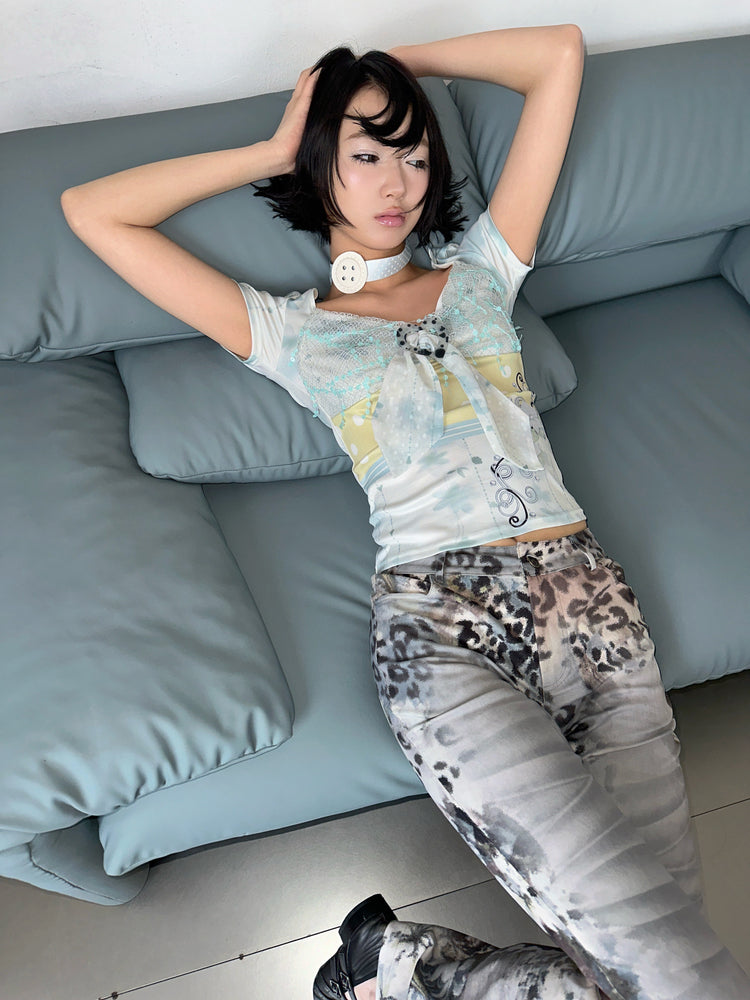 4RE1GN BLUE BLOOM patchwork short-sleeve tee in blue multicolor — modeled view reclining on a sofa