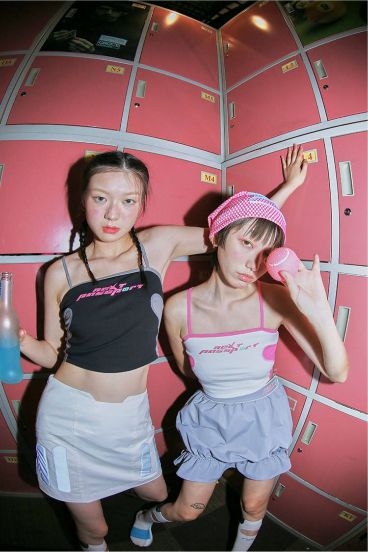 NEXT PASSPORT RETROFUTURE color-block crop camisole — black and white modeled low-angle view showing both contrast-trim colorways.