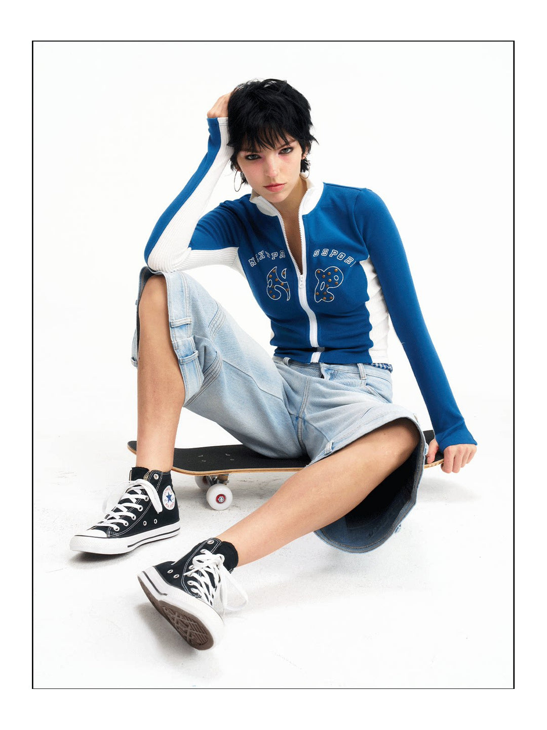 Seated angled studio view of the light-wash cropped jeans