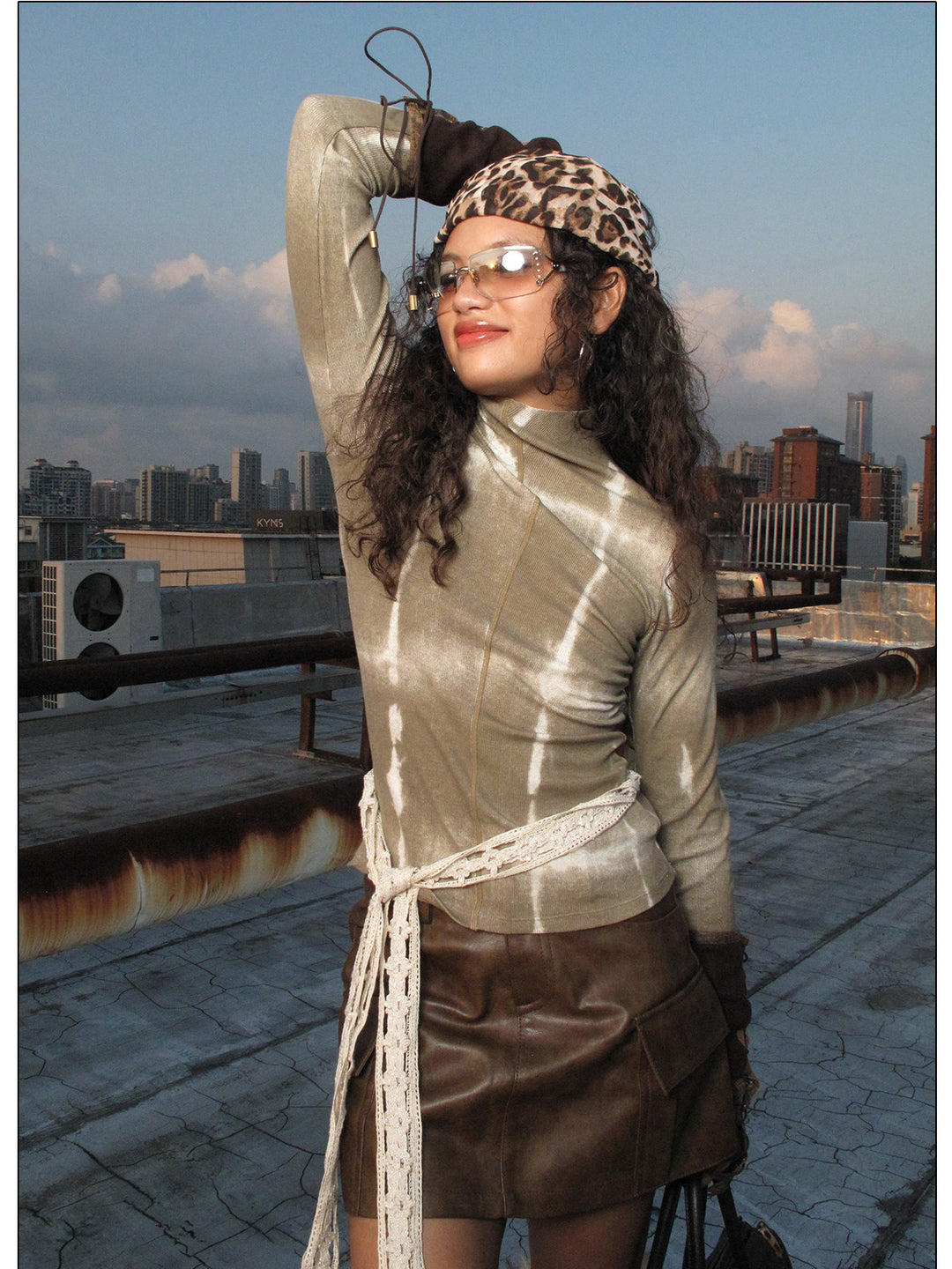NEXT PASSPORT brown fitted mock-neck long-sleeve tee rooftop close-up.