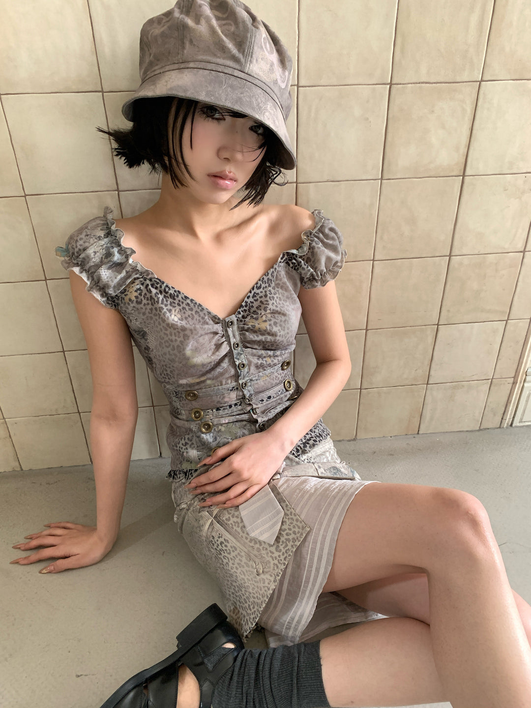 4RE1GN CROSS LEOPARD bow-detail layered skirt in beige multicolor — seated modeled view showing the striped underlayer