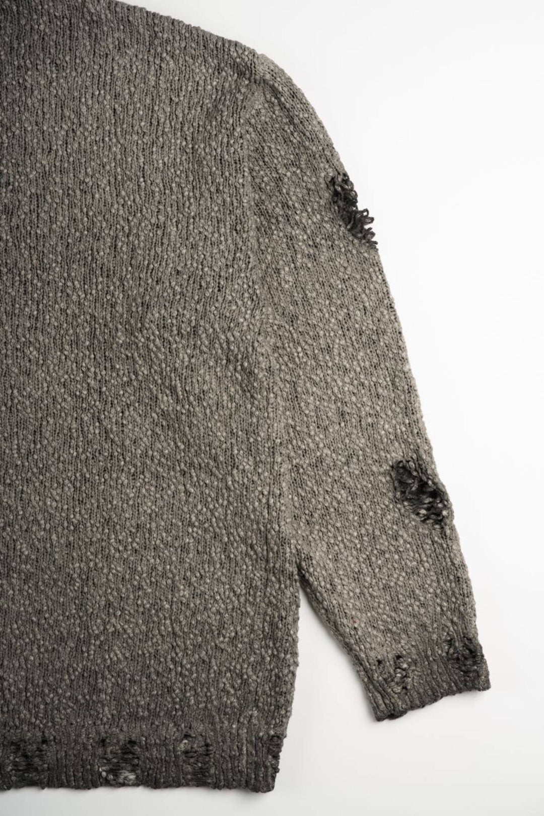 ARTEMIS distressed reversible knit sweater, close-up of the dropped shoulder and distressed sleeve
