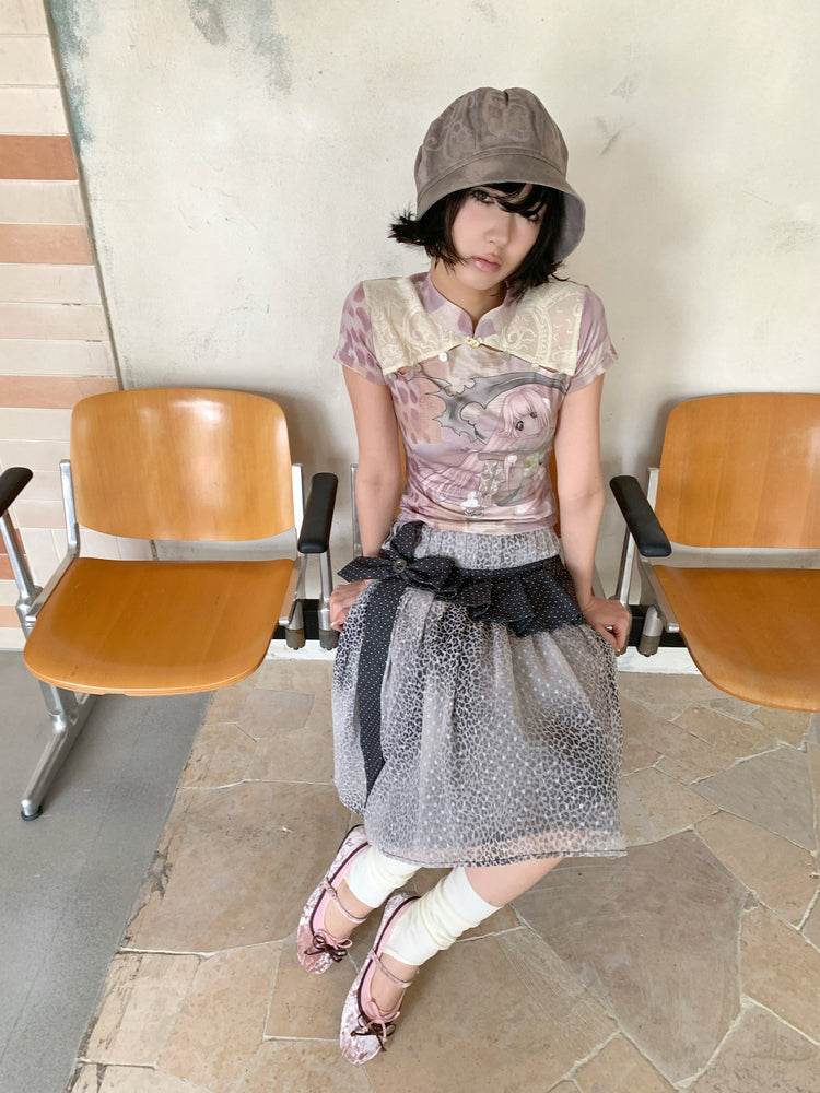 4RE1GN PINK REAPER lace-panel mandarin tee in pink multicolor — front modeled view seated between chairs