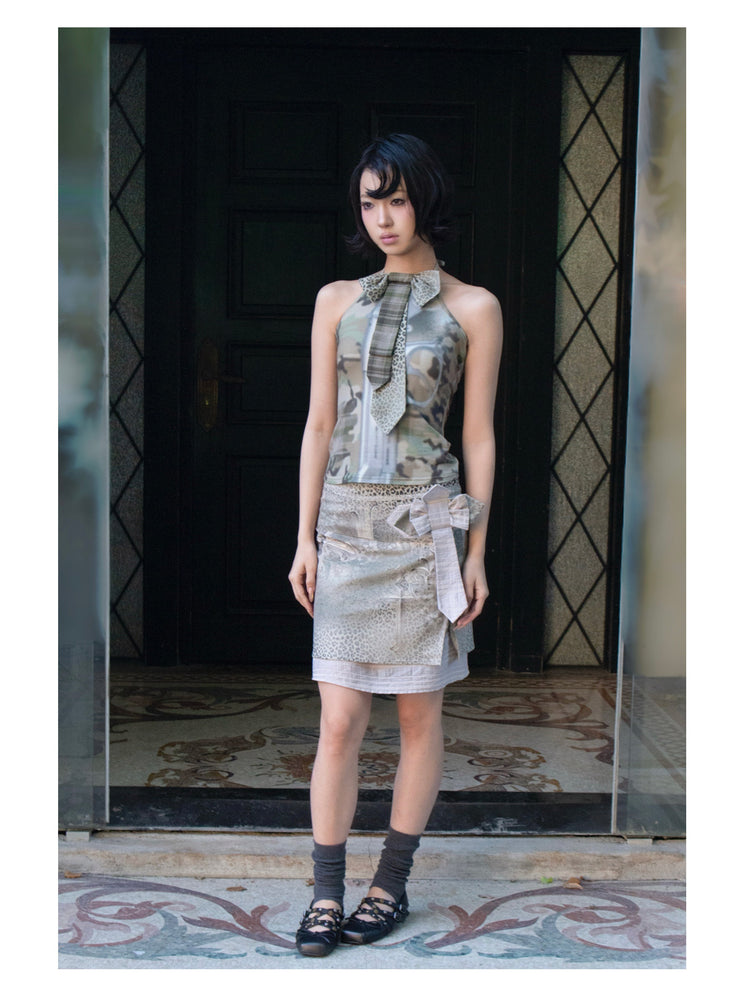 4RE1GN CROSS LEOPARD bow-detail layered skirt in beige multicolor — full-length modeled view in a dark doorway