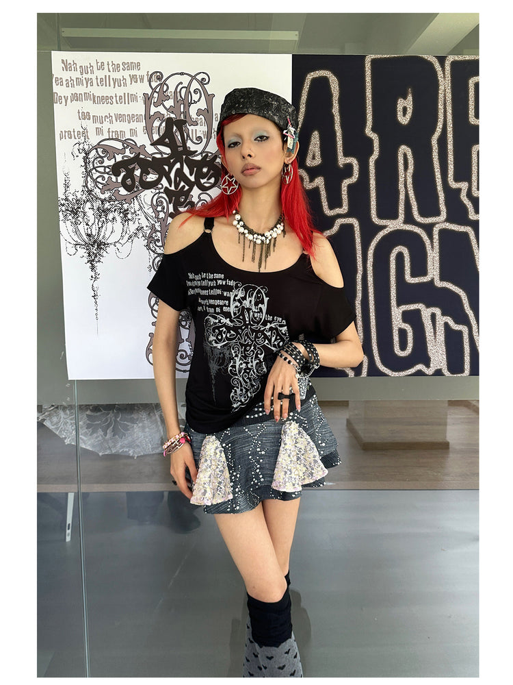 4RE1GN CROSS SCRIPT cold-shoulder tee in black — angled modeled view beside the brand display