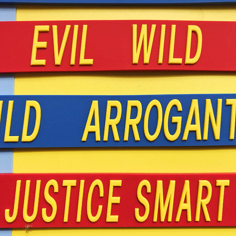 EOH-STUDIO BTBM raised yellow lettering on red and blue silicone, macro construction detail.