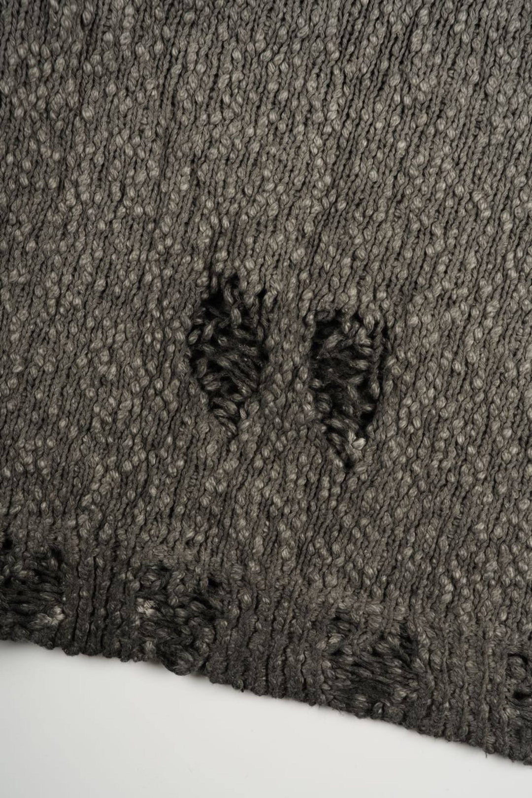 ARTEMIS distressed reversible knit sweater, close-up of the distressed knit hem