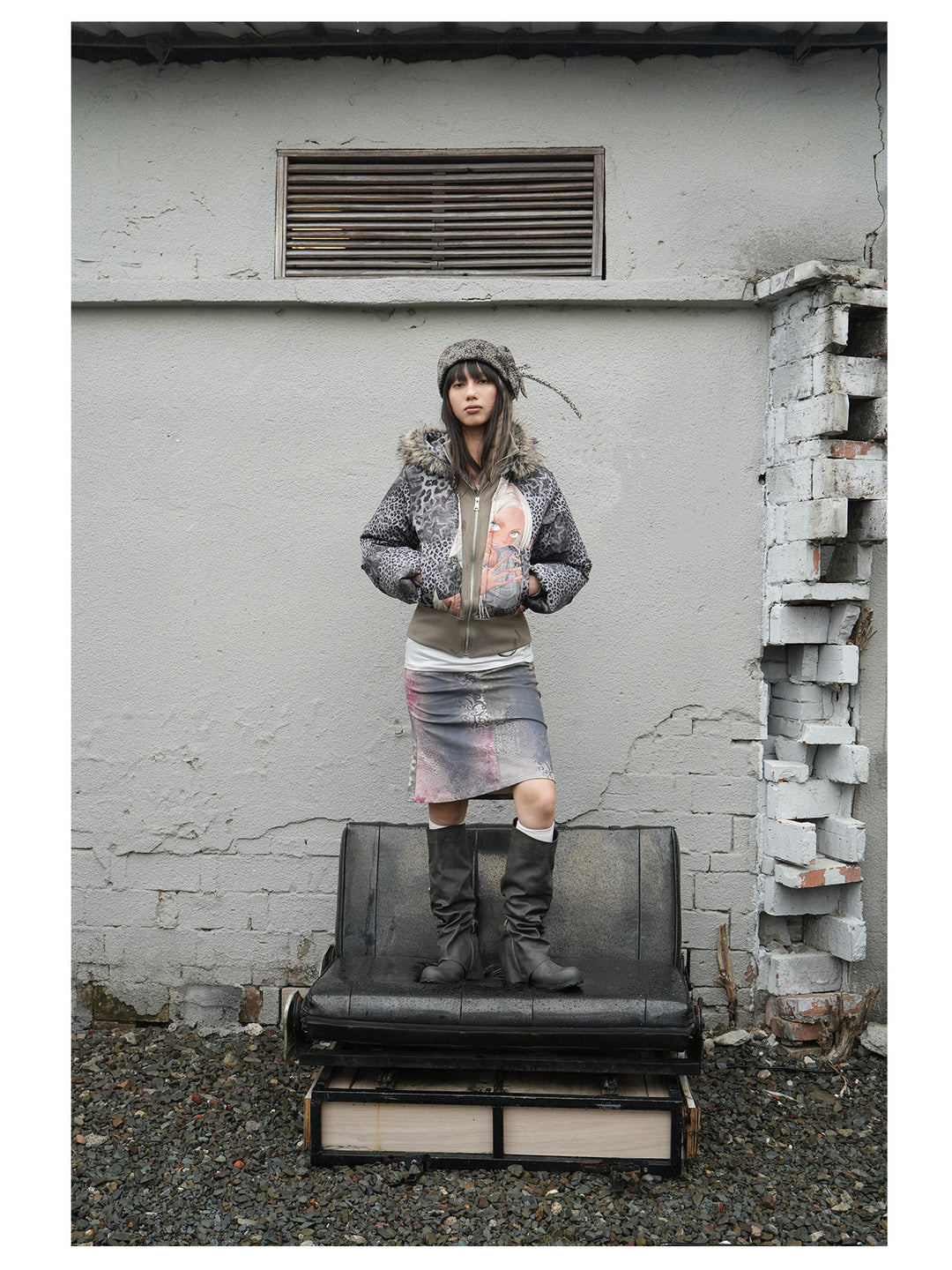 4RE1GN NAILS DONE leopard graphic down jacket in gray multicolor — full-length modeled view standing on a bench