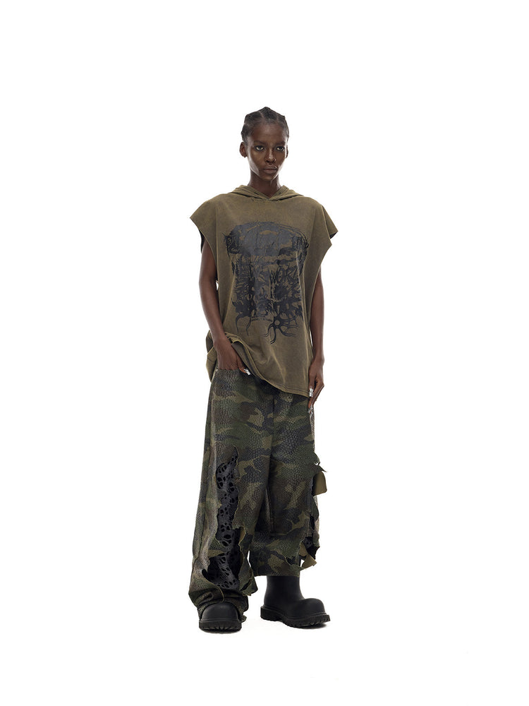 PINKSPINK DOUBLE STACK distressed camouflage wide-leg jeans — angled full-length modeled view with an olive sleeveless top