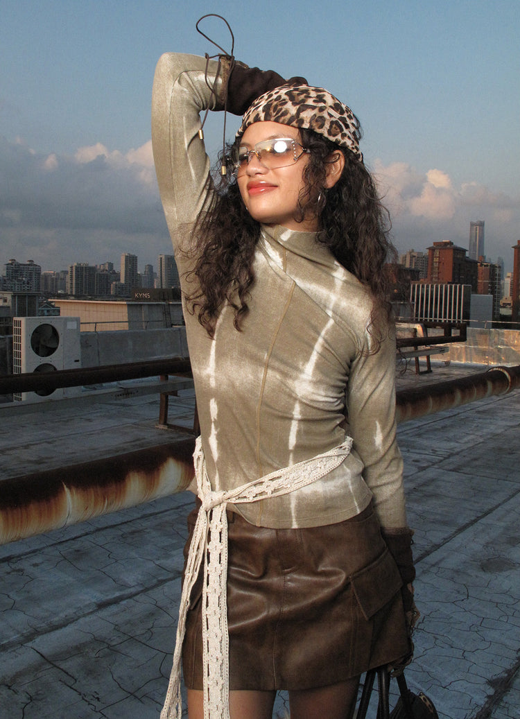 NEXT PASSPORT brown fitted mock-neck long-sleeve tee rooftop close-up.