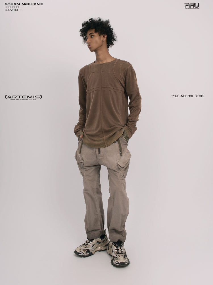 RUSTED ORBIT petrified brown mesh-panel long-sleeve top — full-length front modeled view with hands in pockets