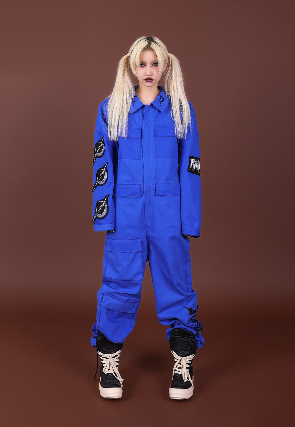 Straight-on view of the blue REMAKE utility jumpsuit with arms lowered and full-length legs