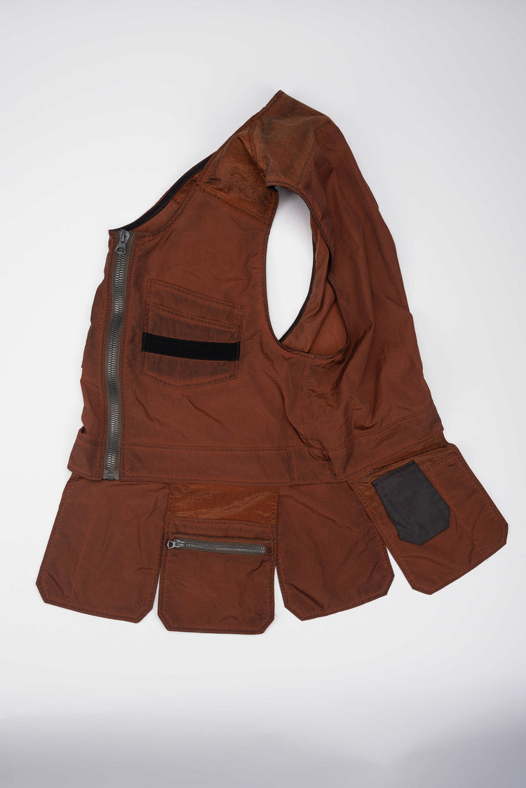 PIONEER sedna-red multi-pocket vest — angled flat-lay showing the side opening and extended pocket panels