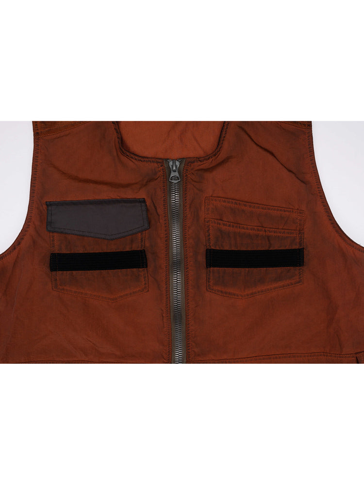 PIONEER sedna-red multi-pocket vest — close-up of the geometric zipper pull and chest-pocket construction