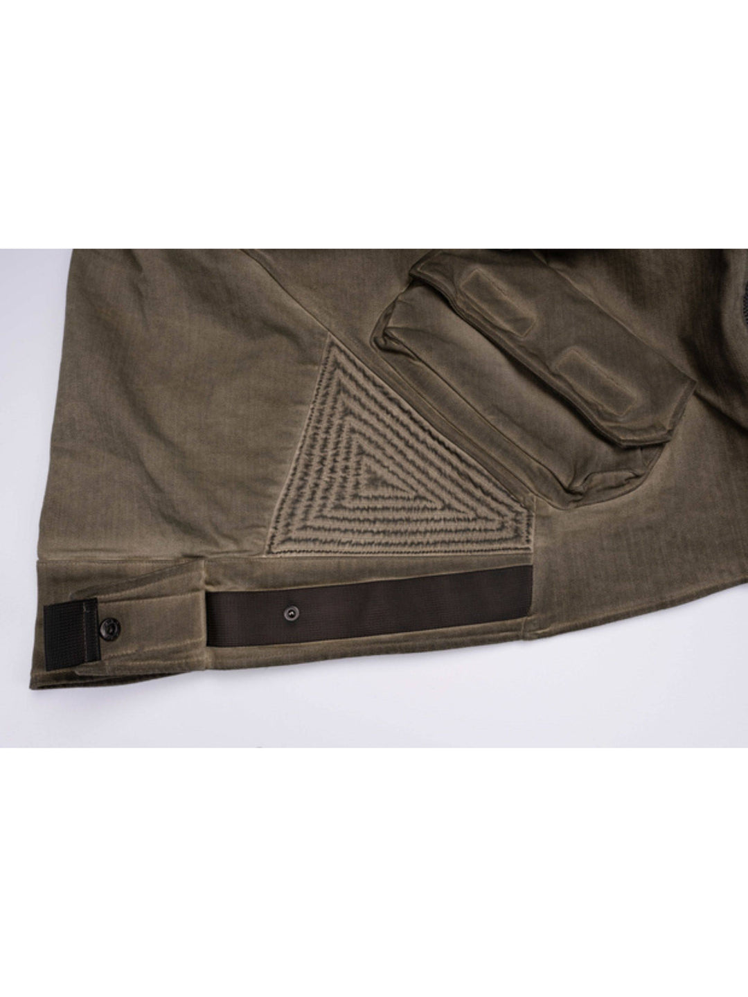 PIONEER mercury-brown detachable-sleeve jacket — close-up of the lower panel stitching and snap-fastened hem tab