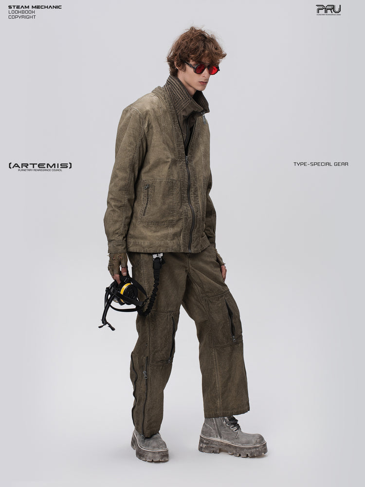 PIONEER knee-mesh utility work pants in lunar soil green — side full-length modeled view with a respirator styling prop