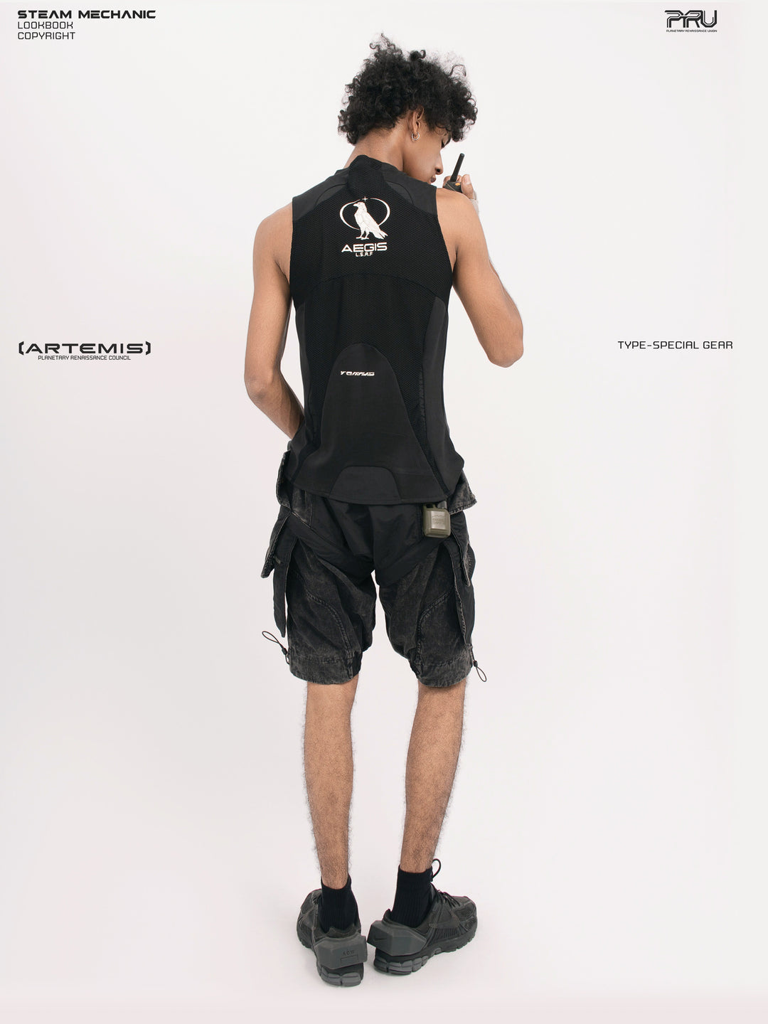 ARTEMIS blackbird black detachable technical shorts — opposite rear three-quarter full-outfit view with a radio styling prop