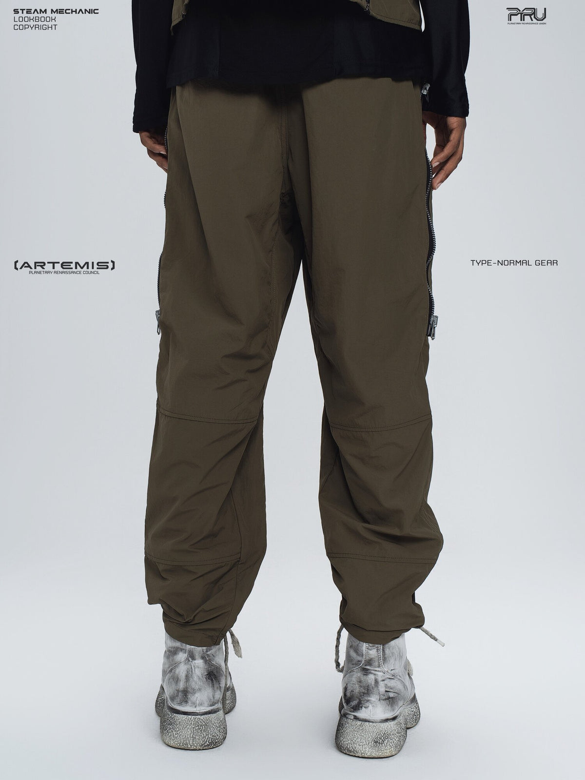 GAIA curved-blade technical pants in stone green — modeled back view showing the tapered legs