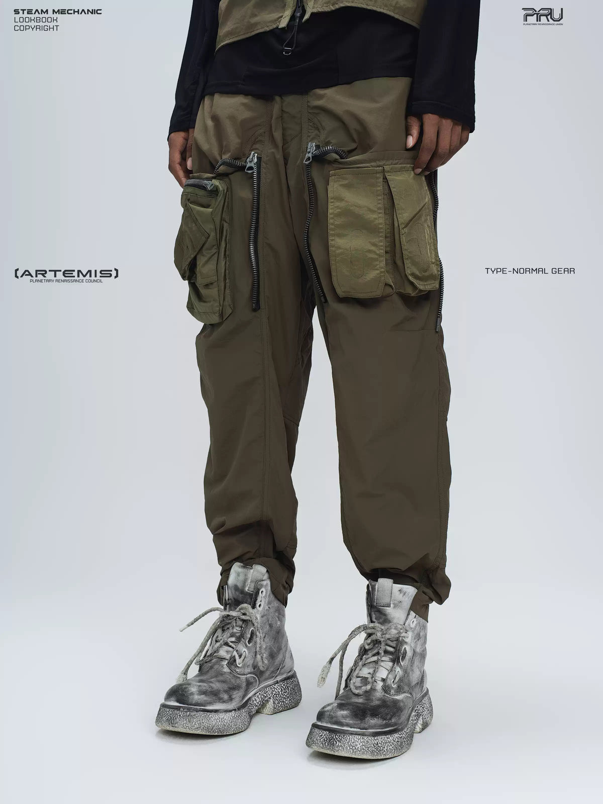 GAIA curved-blade technical pants in stone green — close modeled front view with the zip panels open and cargo pockets exposed