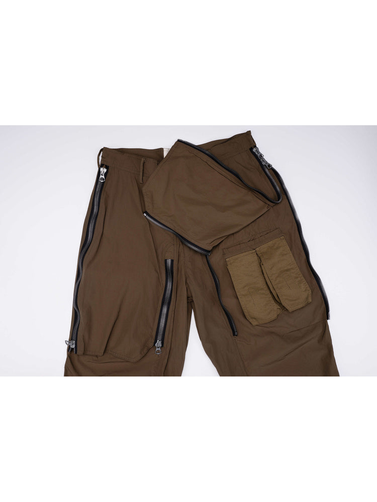 GAIA curved-blade technical pants in stone green — turned-out pocket construction detail