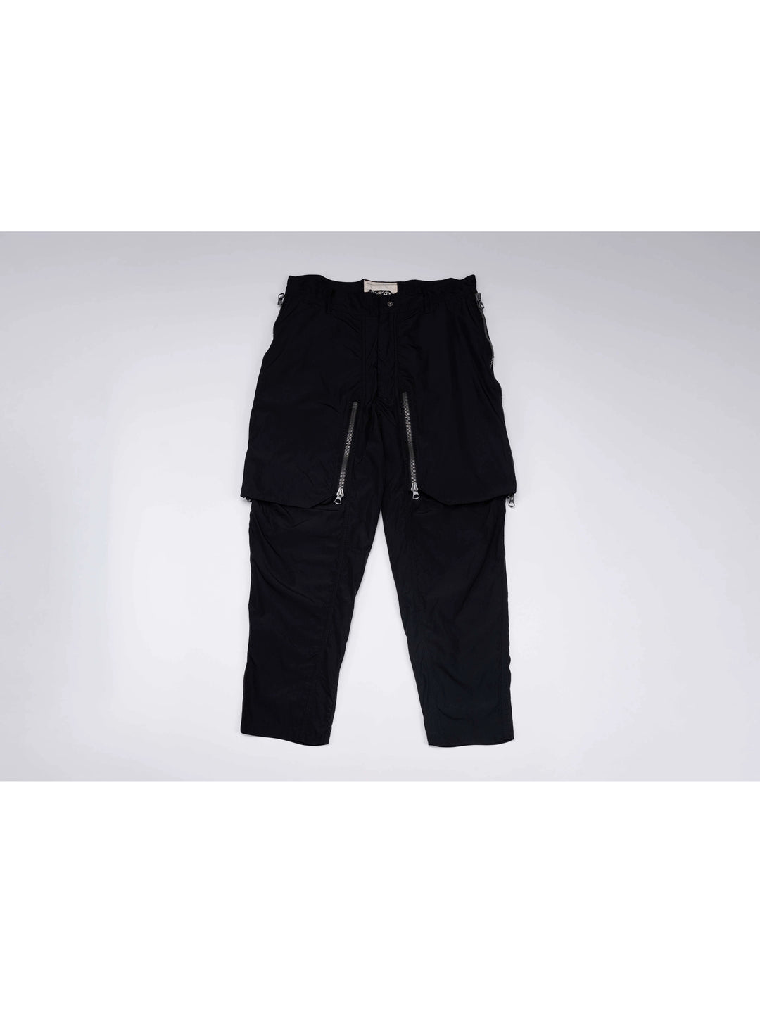 GAIA curved-blade technical pants in night black — front garment-only view with curved zip panels closed
