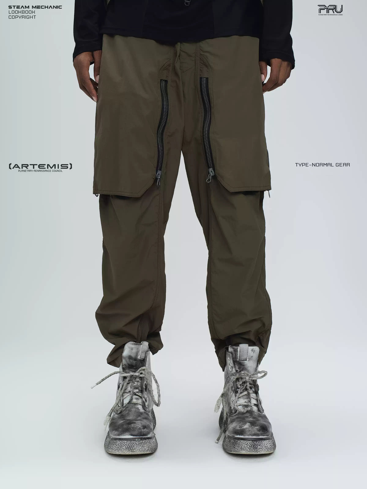 GAIA curved-blade technical pants in stone green — close modeled front view with the zip panels closed