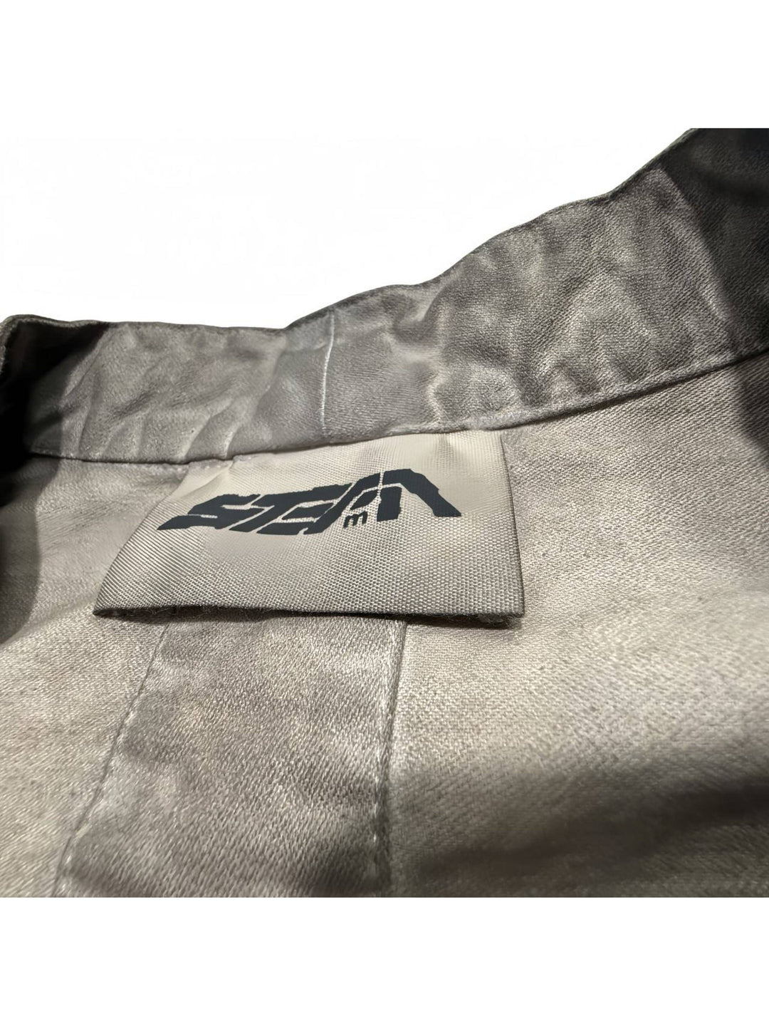 GAIA gravel brown open-collar technical robe — gravel brown inner neckline and brand label close-up