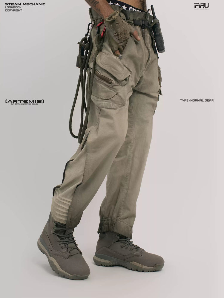 AEGIS lunar soil teal multi-pocket moto pants — front three-quarter modeled view with a hand in the cargo pocket