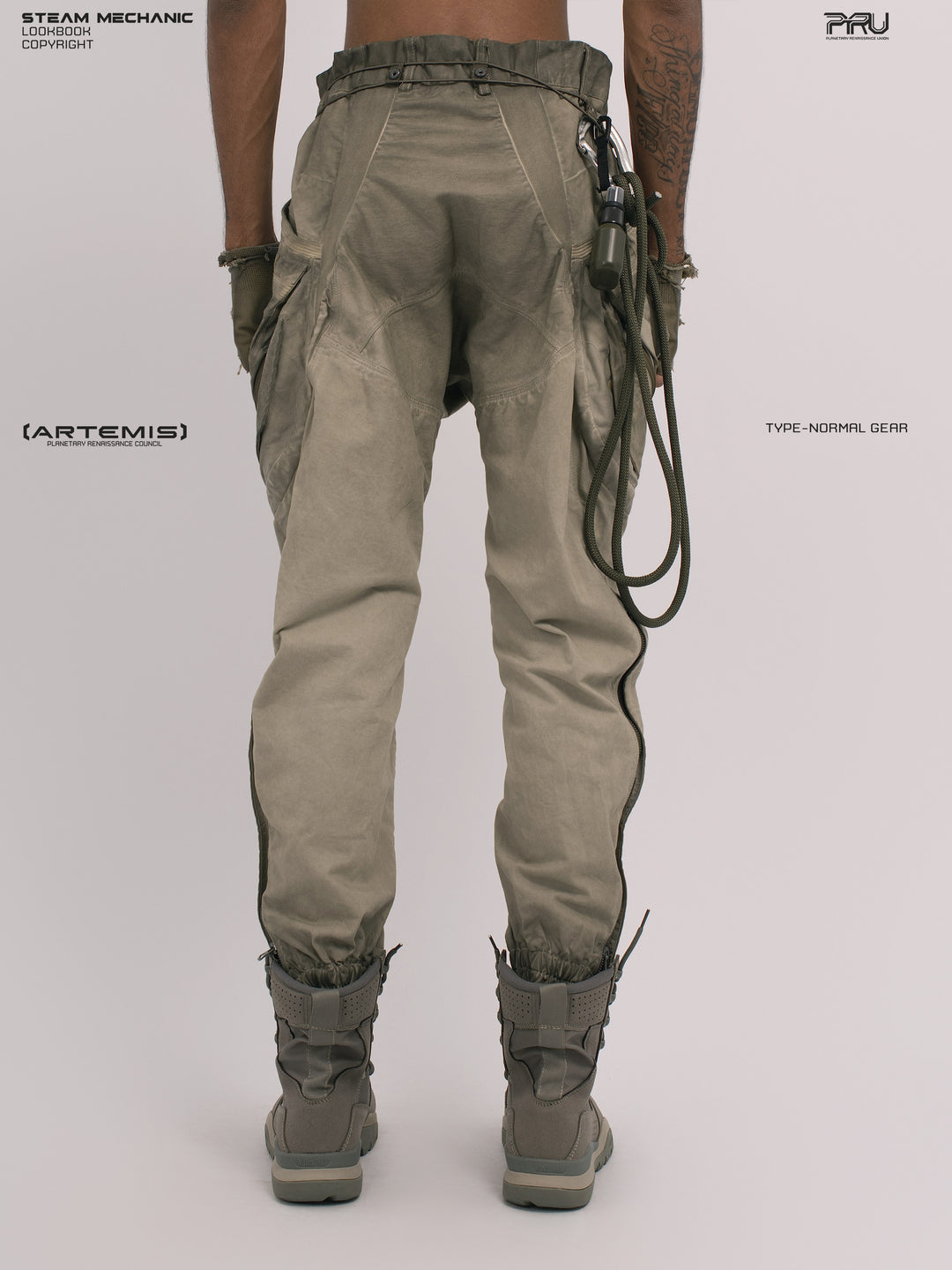 AEGIS lunar soil teal multi-pocket moto pants — rear modeled view with gloved hands angled inward