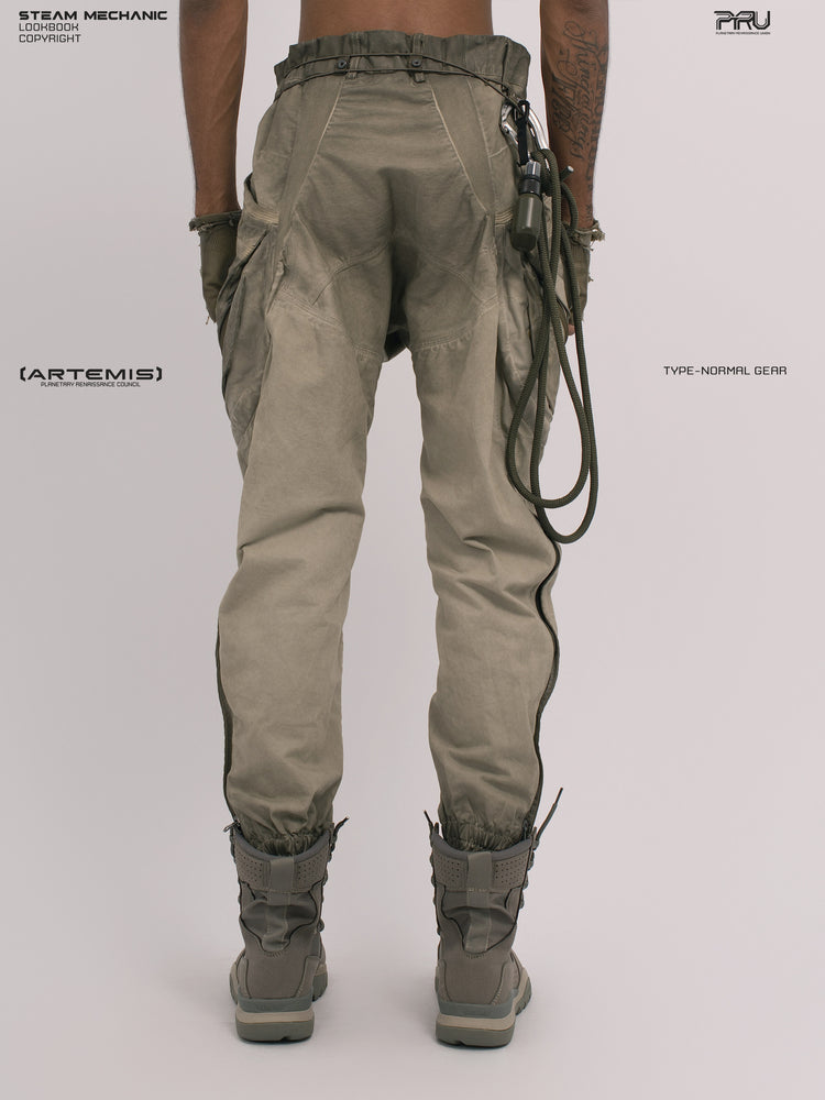 AEGIS lunar soil teal multi-pocket moto pants — rear modeled view with gloved hands angled inward