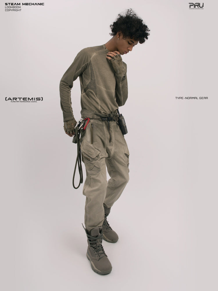 AEGIS lunar soil teal multi-pocket moto pants — full-length three-quarter front modeled view with one hand at the collar