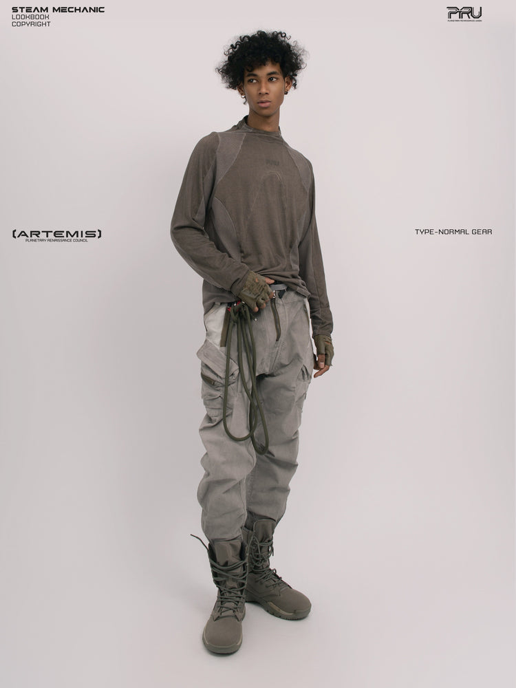 AEGIS lunar sea gray multi-pocket moto pants — full-length three-quarter front modeled view with a hand at the waistband