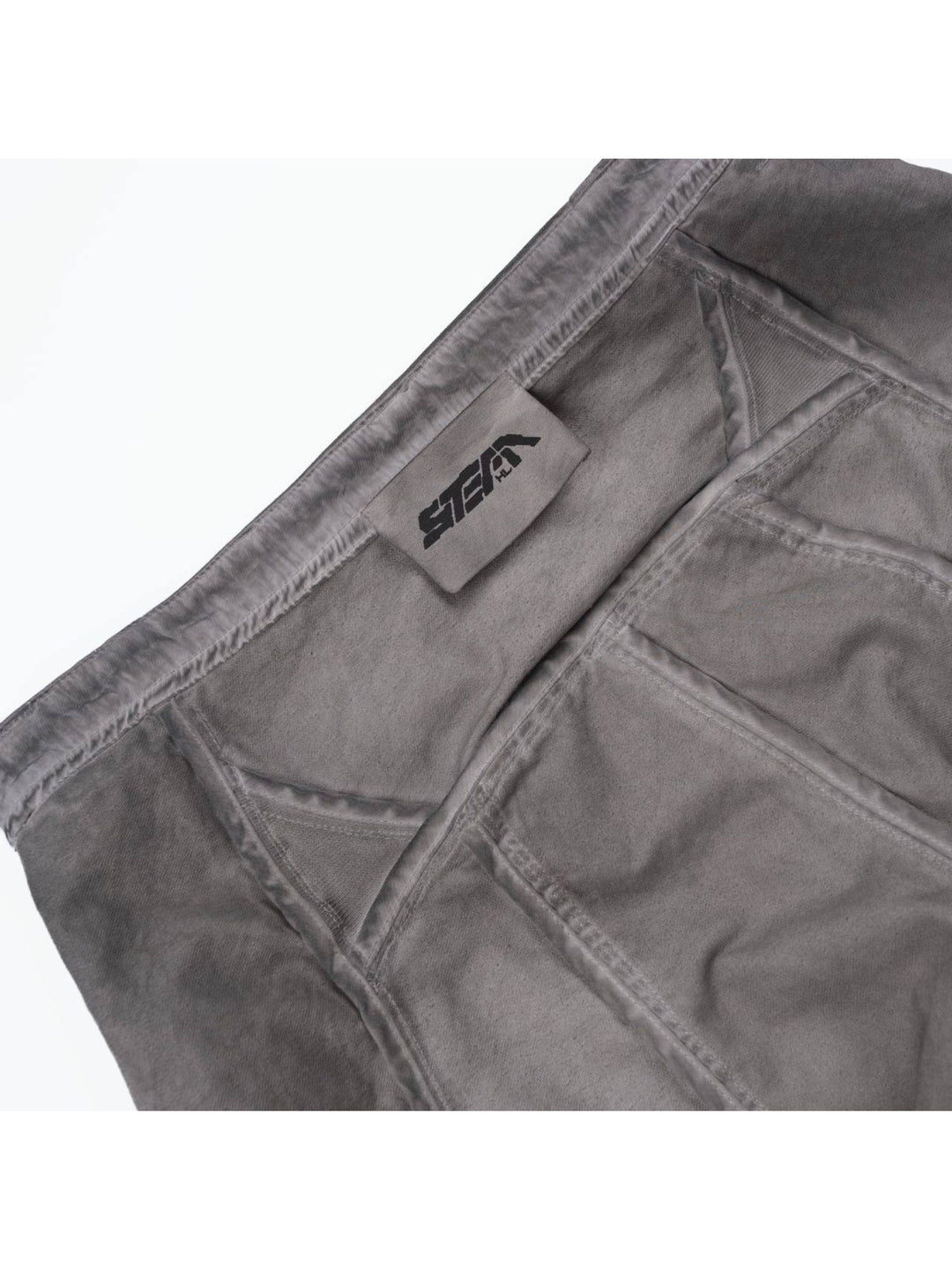 AEGIS eris white cropped moto riding pants — inside waistband detail showing the sewn STEAM brand label