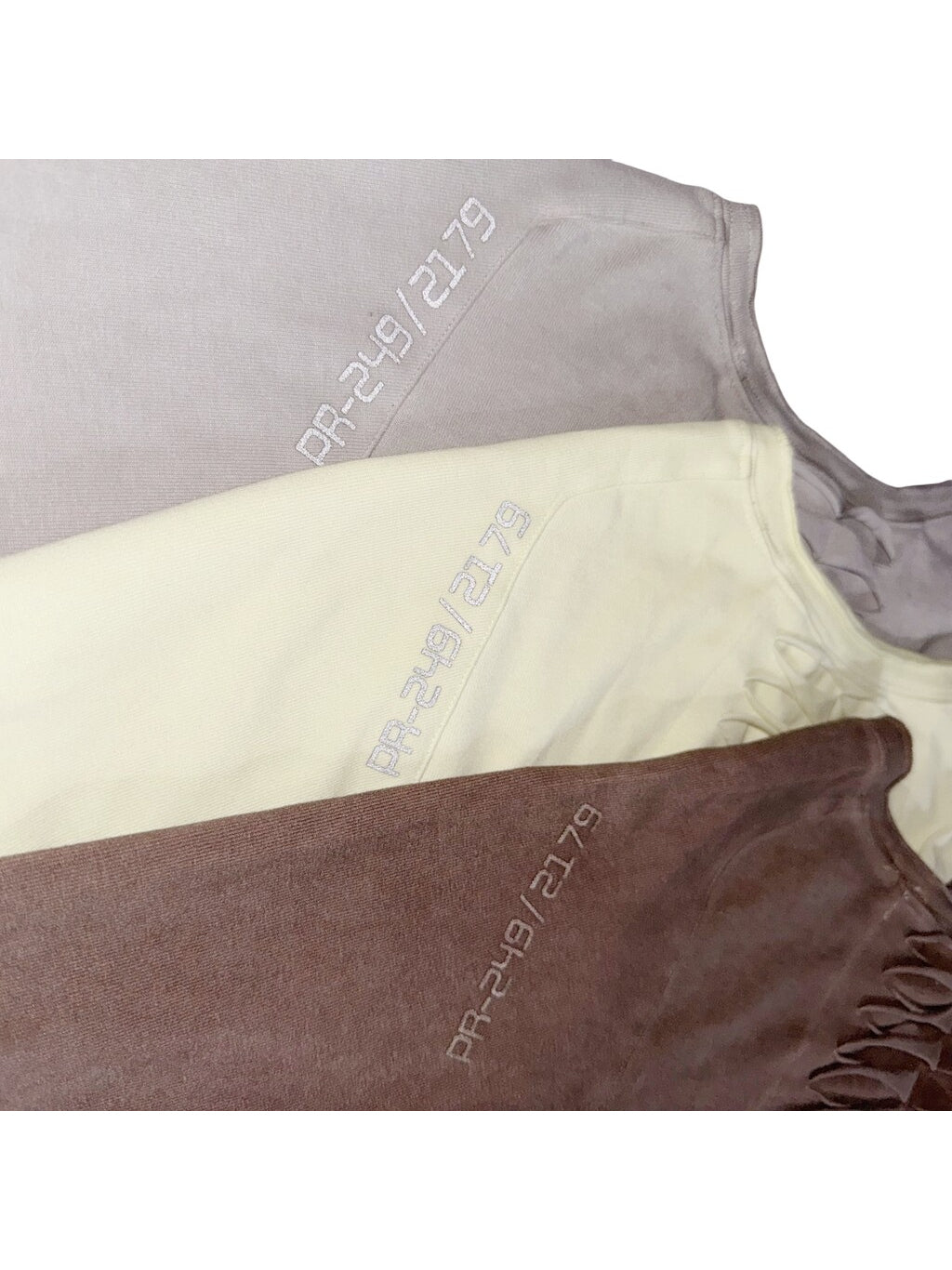 ERODED SPINE distressed asymmetric tee — reflective back-shoulder codes across all three colors