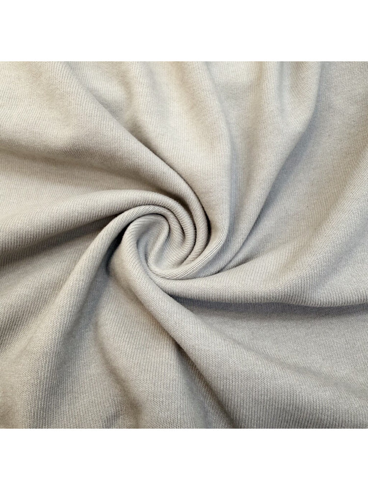 ERODED SPINE distressed asymmetric tee — close-up of the washed cotton fabric texture
