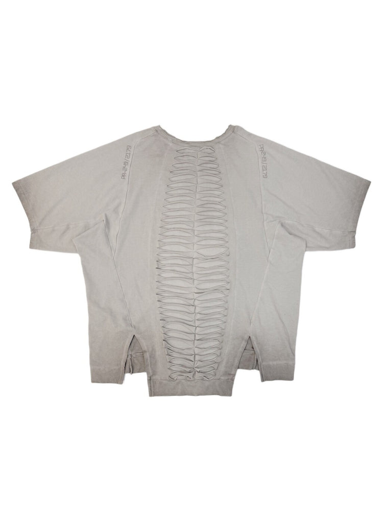 ERODED SPINE distressed asymmetric tee — oxidized white back flat lay showing the spine-like cutouts