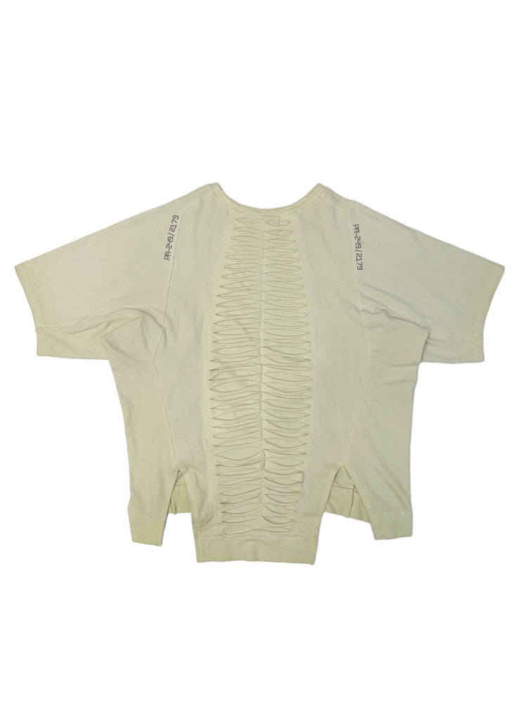 ERODED SPINE distressed asymmetric tee — aurora green back flat lay showing the spine-like cutouts