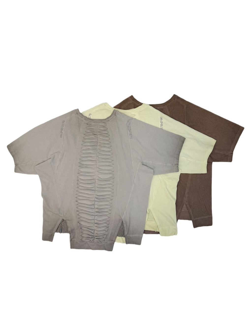 ERODED SPINE distressed asymmetric tee — back flat lays of all three colors showing the panel construction