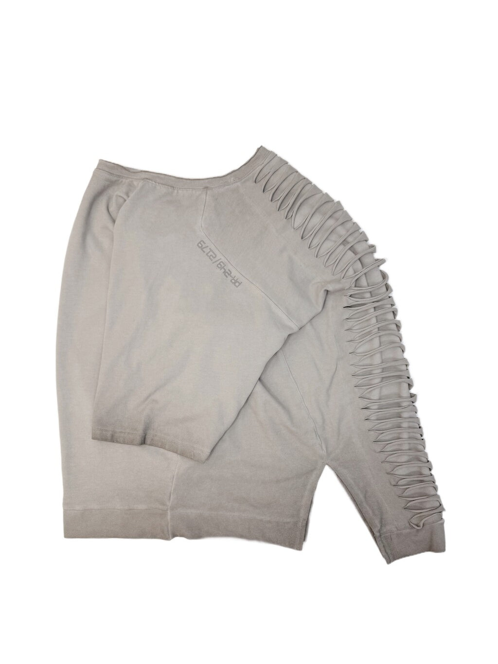 ERODED SPINE distressed asymmetric tee — folded oxidized white tee showing the back cutouts and washed texture