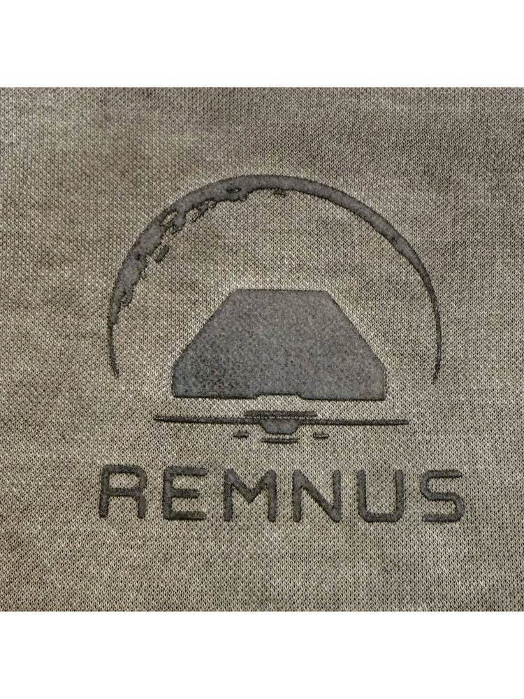 TWIN STAR lunar soil teal stretch riding base-layer top — close-up of the REMNUS chest print on lunar soil teal knit fabric