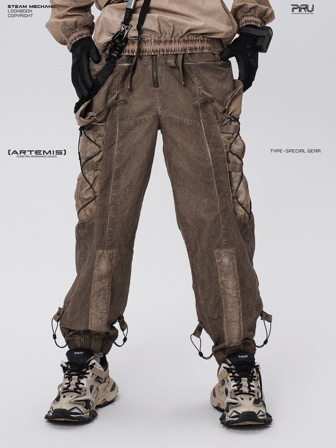 PIONEER detachable waist-pouch cargo pants in gravel brown — front close-up with hands at the waist