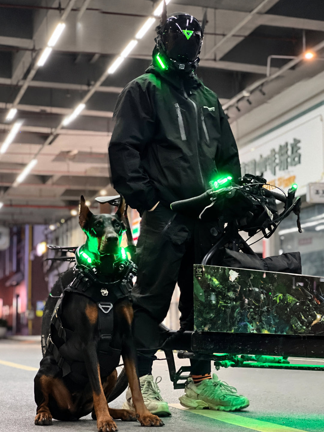 FOCKSHOP ANUBIS black illuminated horned cyber mask — full-length modeled view beside a bicycle and dog