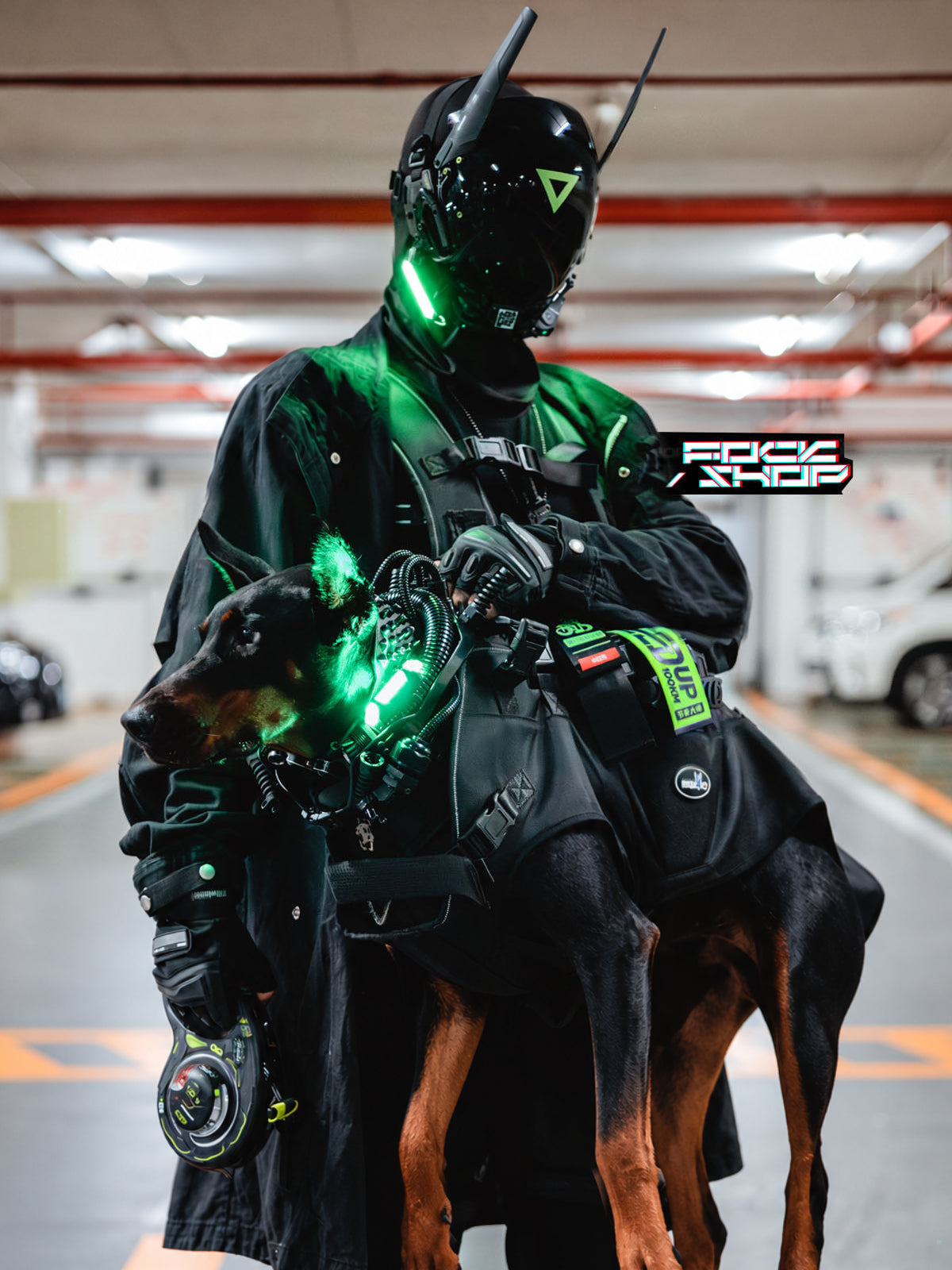 FOCKSHOP ANUBIS black illuminated horned cyber mask — close modeled view with the green light illuminated, holding a dog