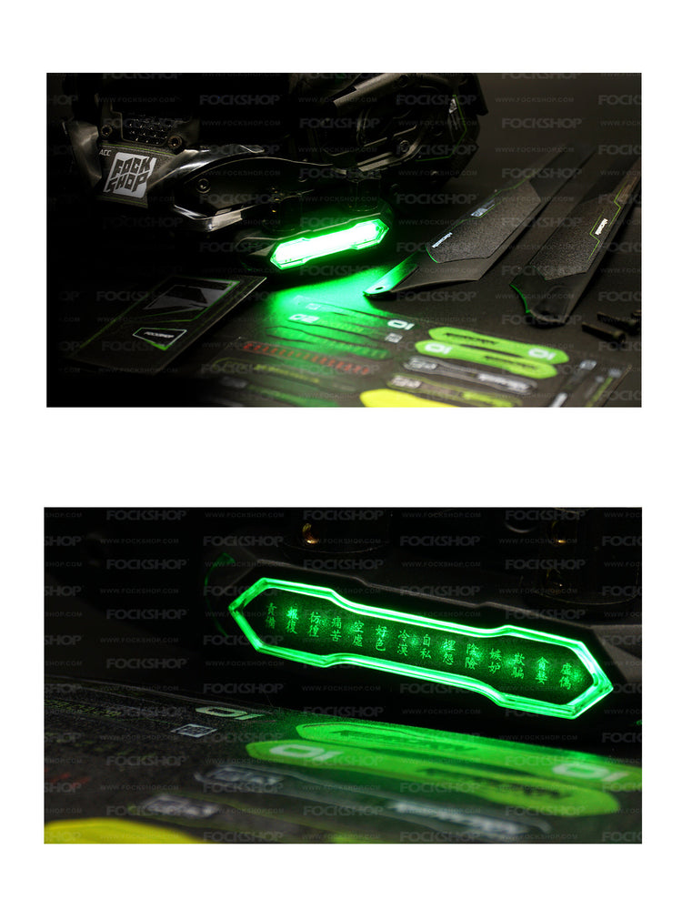 FOCKSHOP ANUBIS black illuminated horned cyber mask — tabletop detail of the green light and decorative stickers, with a close-up of the illuminated panel