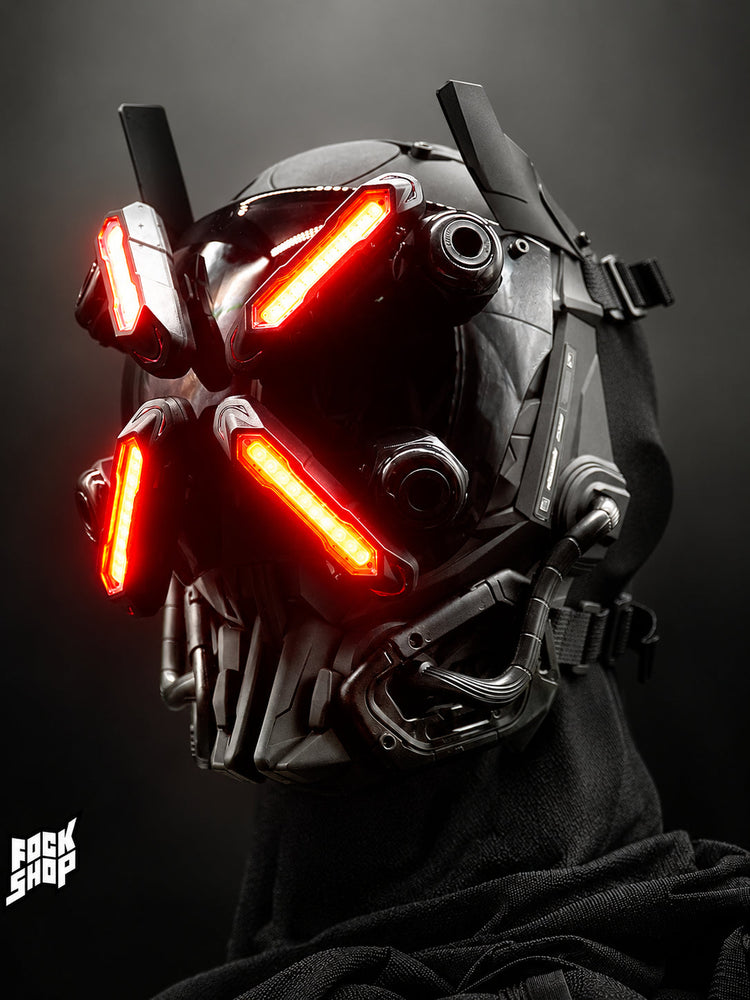 FOCKSHOP EYE II black illuminated cyber mask — close-up of red illuminated panels and mechanical visor frame on a dark background