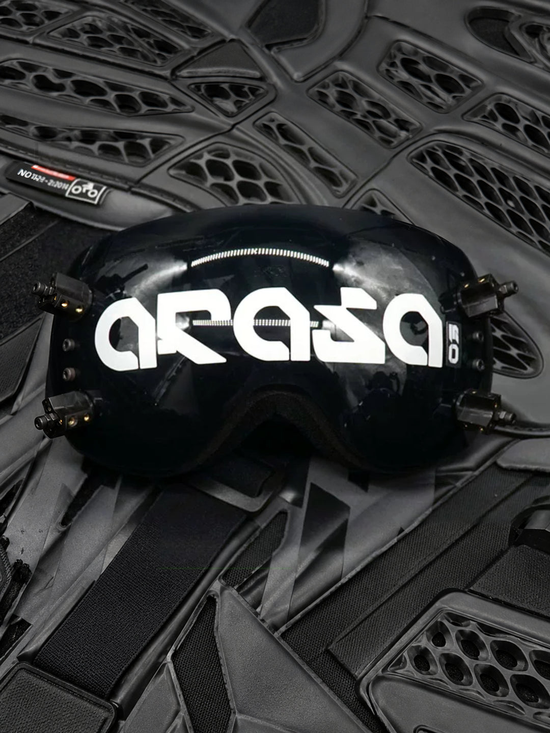 FOCKSHOP KORAN cyber goggles — ARASA lettered black mirrored visor displayed on dark mechanical equipment