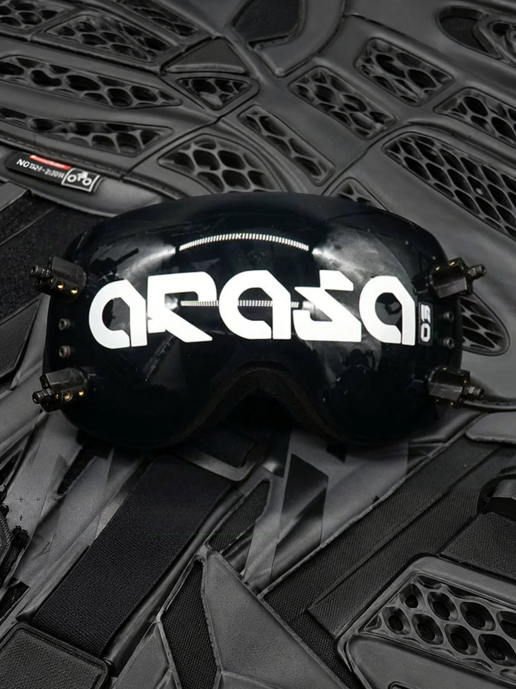 FOCKSHOP KORAN cyber goggles — ARASA lettered black mirrored visor displayed on dark mechanical equipment