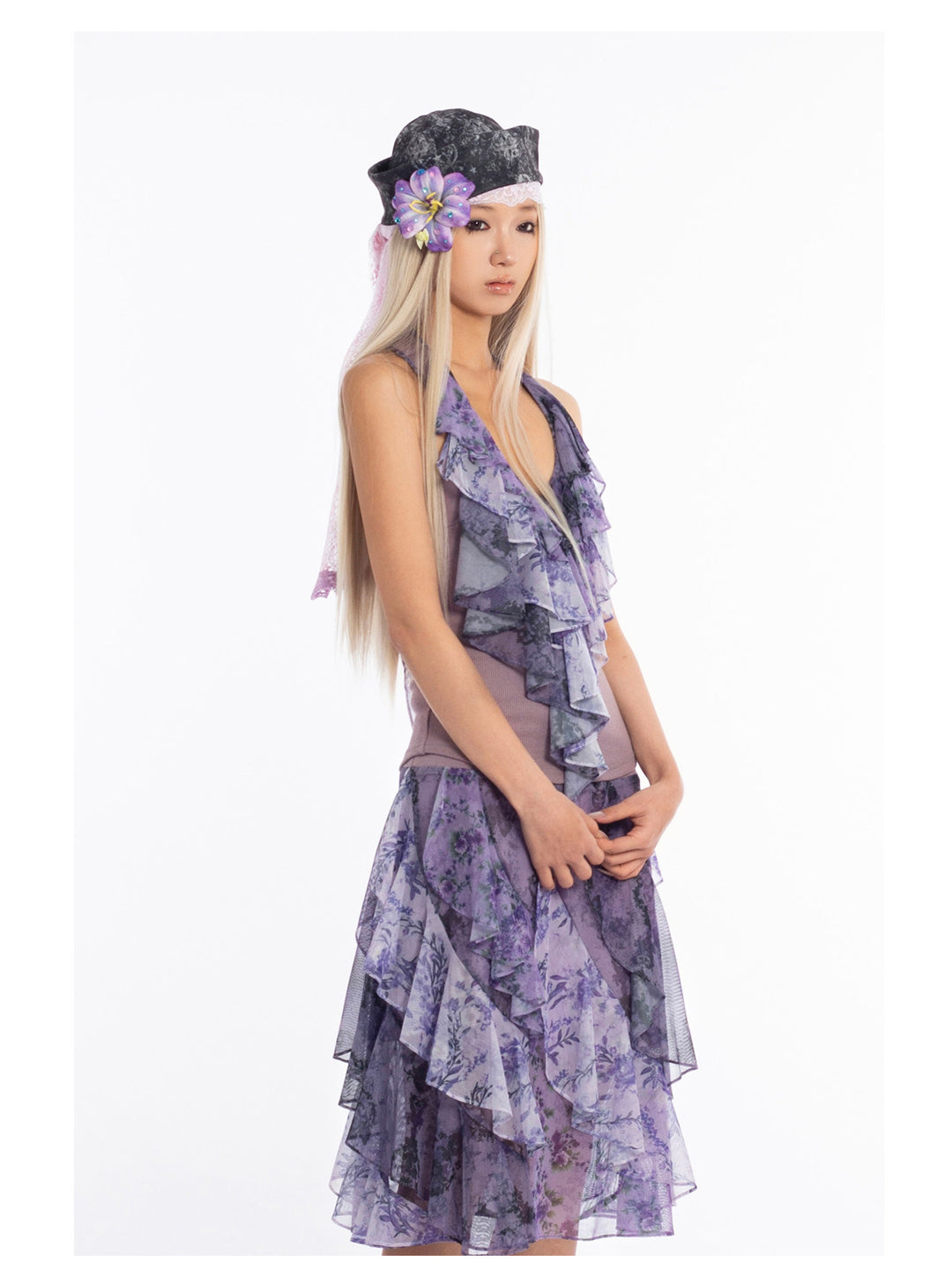 4RE1GN PURPLE HAZE asymmetric ruffle skirt in purple — closer three-quarter modeled view with hands in front