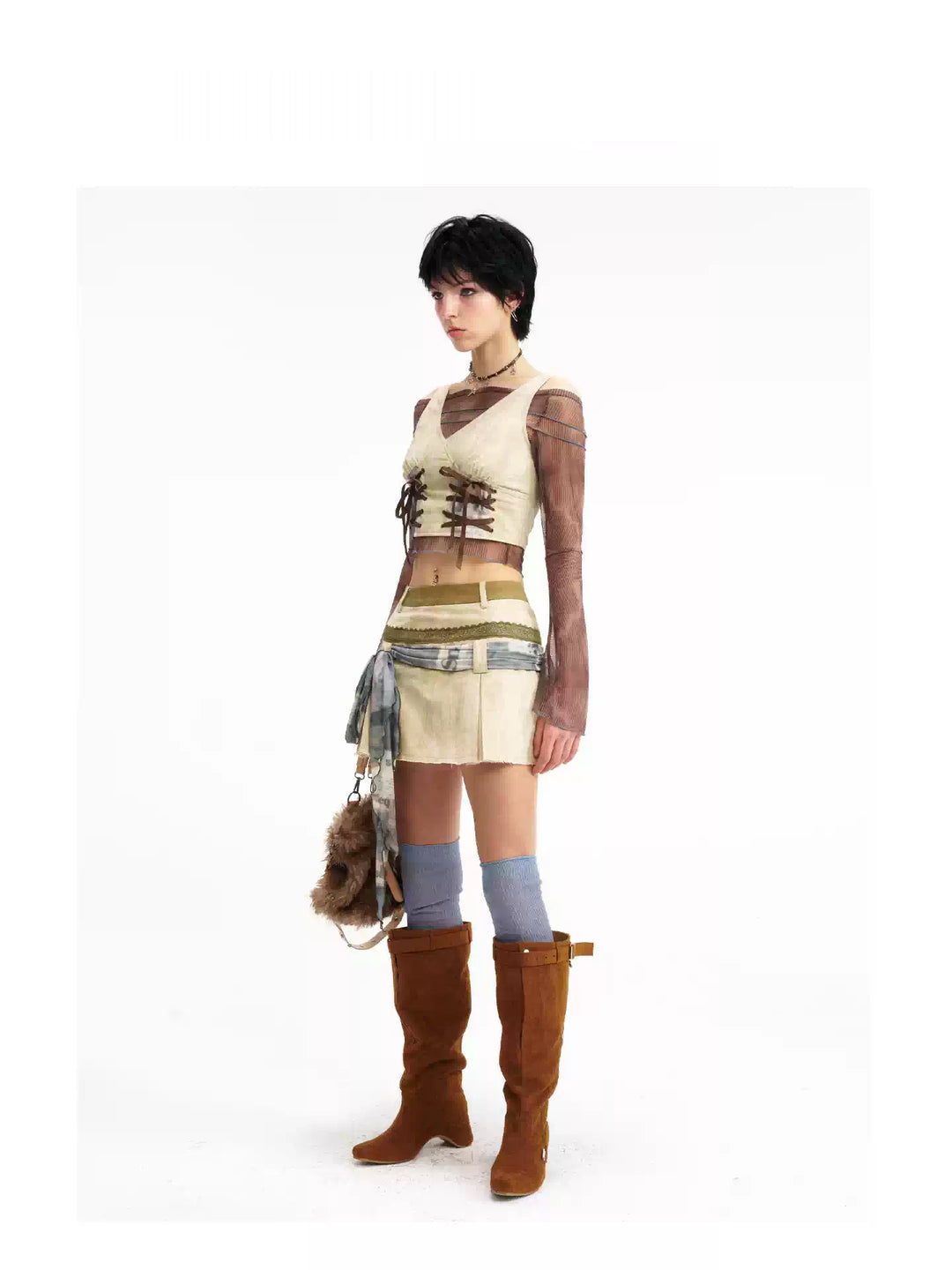 Three-quarter view of the lace-up vest and pleated mini skirt